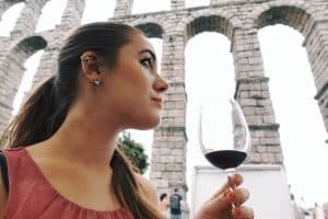 girl drinking red wine by the aqueduct of segovia